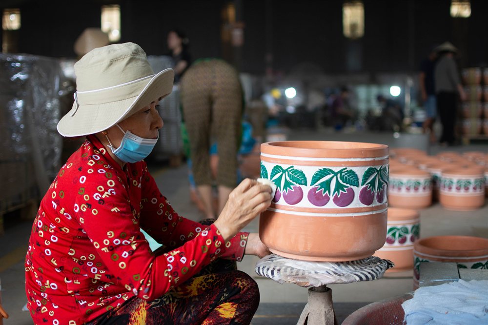 Artisan hand-painting a terracotta pot